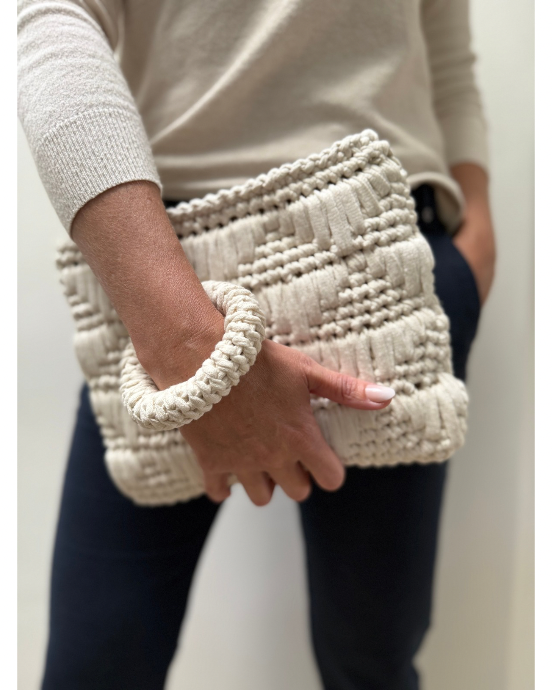 This modern clutch is stylish and functional. It features an attachable crochet bangle for a secure, hands-free hold that adds a playful yet practical twist.